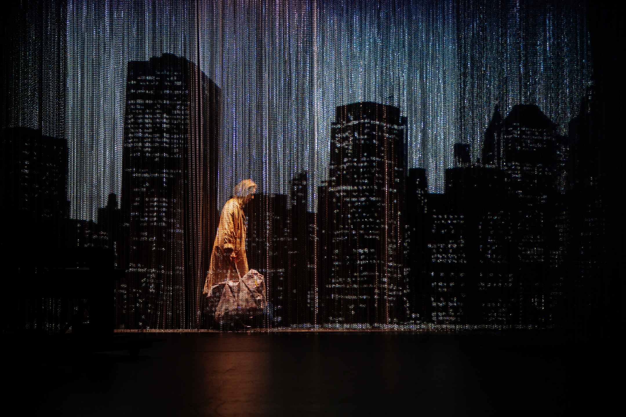 © Samuel Rubio – La femme sans nom, par Marthe Keller, déambulant dans un New York extérieur, sous le filtre des rideaux perlés